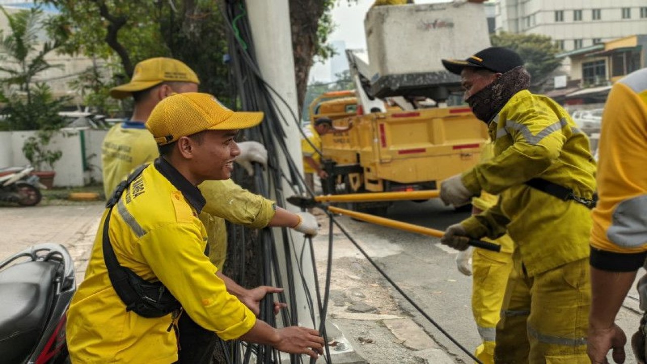 Personel Suku Dinas Bina Marga Jakarta Selatan tengah menertibkan kabel udara sepanjang lima kilometer di Jalan Tuti Alawiyah, Mampang Prapatan, Jakarta, Senin (8/5/2023). ANTARA/HO-Kominfotik Jakarta Selatan