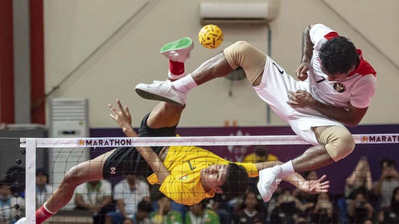 Pesepak takraw Indonesia Saiful Rizal (kanan) berusaha menahan rejaman (smash) tim sepak takraw putra Myanmar Shein Wunna Zaw (kiri) pada pertandingan final sepak takraw beregu putra SEA Games 2023 di National Olympic Stadium, Phnom Penh, Kamboja, Sabtu (13/5/2023). Tim sepak takraw beregu putra Indonesia berhasil meraih medali emas setelah mengalahkan tim sepak takraw beregu putra Myanmar dengan skor 2-0 (42-33 dan 57-53). ANTARA FOTO/Muhammad Adimaja/aww.
