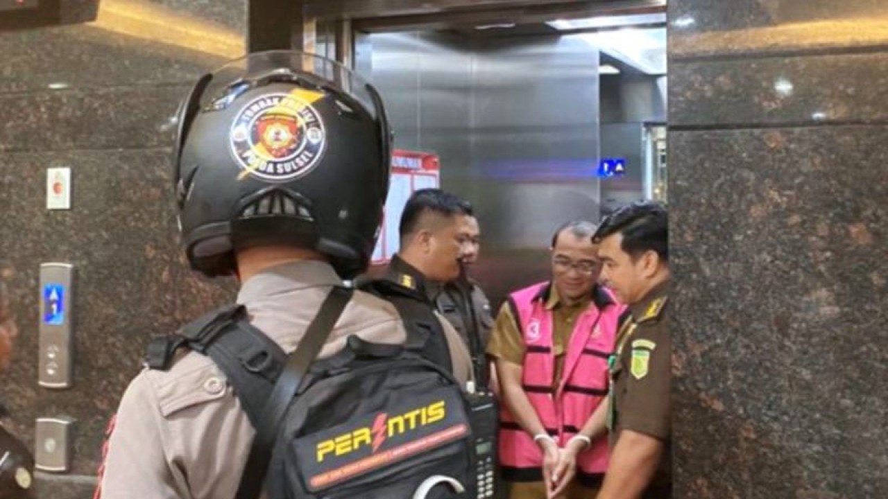 Seorang tersangka dugaan korupsi harga jual tambang pasir laut di giring petugas kepolisian untuk di bawa ke Lapas Kelas I Makassar saya rilis kasus du kantor Kejaksaan Tinggi Sulawesi Selatan, Makassar, Senin (8/5/2023) malam. ANTARA/Darwin Fatir.