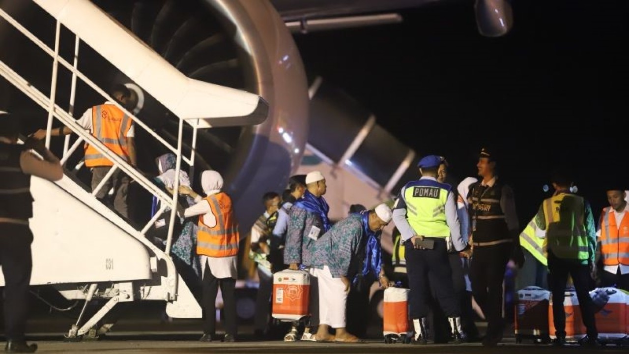 Jamaah calon haji asal Aceh dalam kloter tiga menaiki pesawat yang akan berangkat menuju Madinah, Arab Saudi melalui Bandara Sultan Iskandar Muda (SIM) Aceh Besar, Jumat (26/5/2023). (ANTARA/HO-PPIH Embarkasi Aceh)
