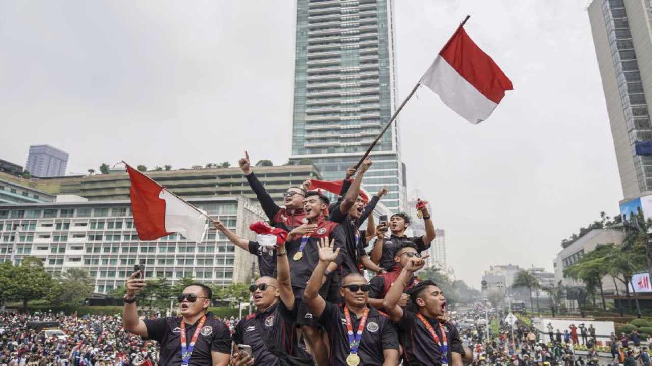 Pesepak bola Timnas Indonesia U-22 bersama ofisial berada di atas bus saat mengikuti arak-arakan di kawasan Bundaran HI, Jakarta, Jumat (19/5/2023). ANTARA FOTO/Dhemas Reviyanto/rwa.