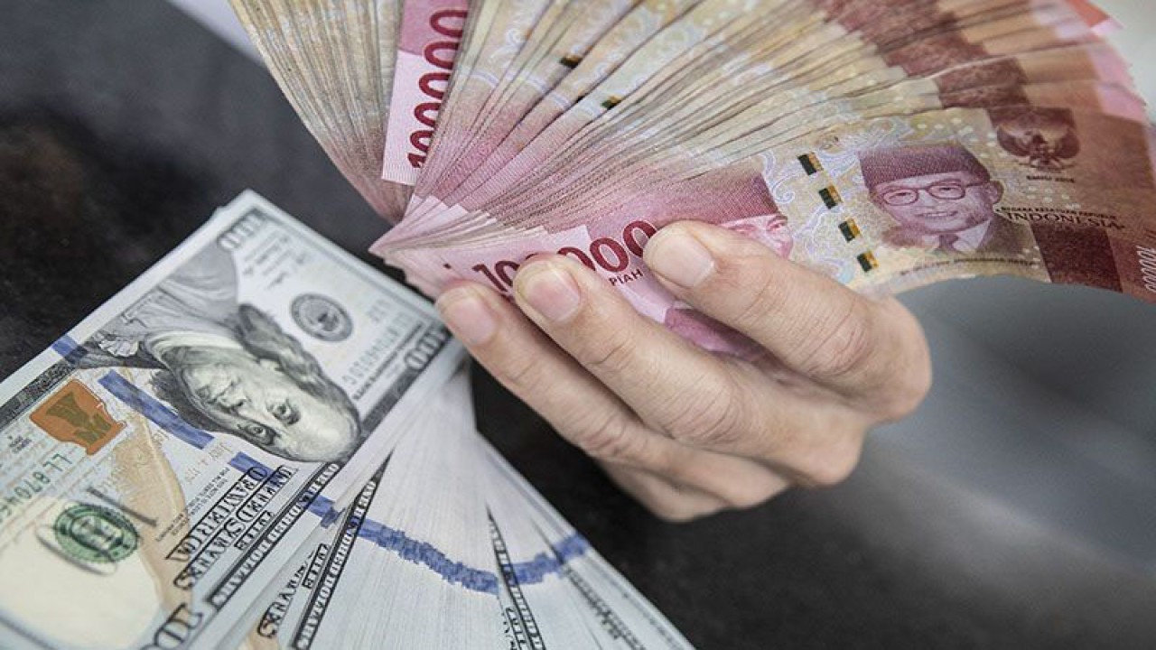 Ilustrasi - Petugas menunjukkan uang pecahan rupiah dan dolar AS di gerai penukaran mata uang asing di Jakarta. ANTARA FOTO/Muhammad Adimaja/foc/pri.
