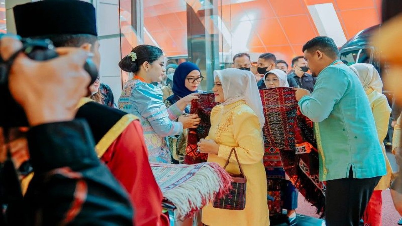 Ibu Negara Iriana Joko Widodo (tengah) dipasangkan kain ulos oleh Wali Kota Medan Bobby Nasution (kanan) bersama Ketua Dekranasda Kota Medan Kahiyang Ayu (kiri) ketika meninjau Expo Dekranas 2023 di Lapangan Benteng Medan, Selasa (16/5/2023). ANTARA/HO-Diskominfo Kota Medan