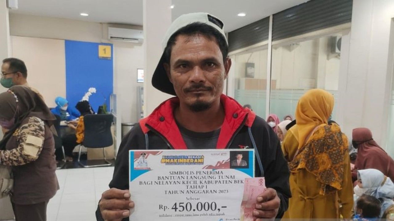Seorang nelayan asal Kecamatan Muaragembong, Kabupaten Bekasi, Jawa Barat menerima bantuan subsidi upah dari Pemkab Bekasi di Kantor Cabang Pembantu Bank Jabar Banten Sukatani, Selasa. (ANTARA/Pradita Kurniawan Syah).