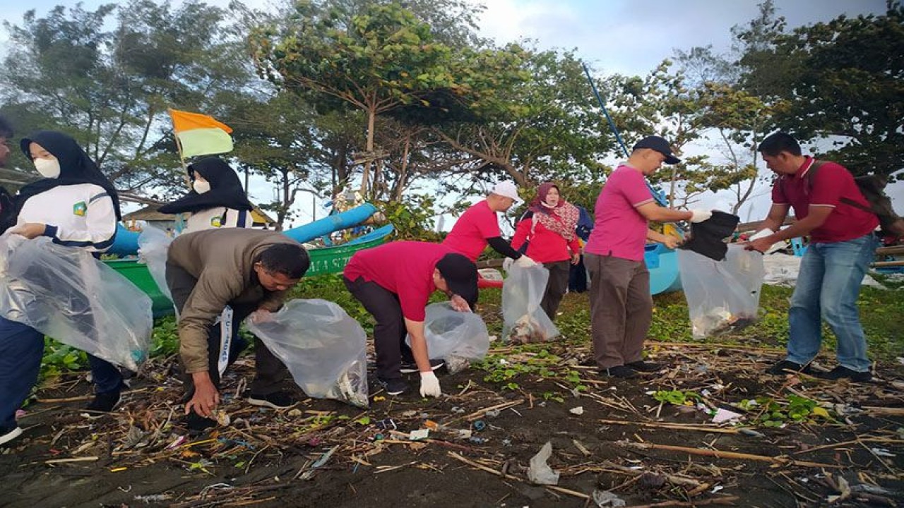 Peserta Aksi Bersih-Bersih Pantai Teluk Penyu memunguti sampah yang berserakan di area Pantai Teluk Penyu, Cilacap, Jawa Tengah, Jumat (9/6/2023) pagi. (ANTARA/HO-SBI)