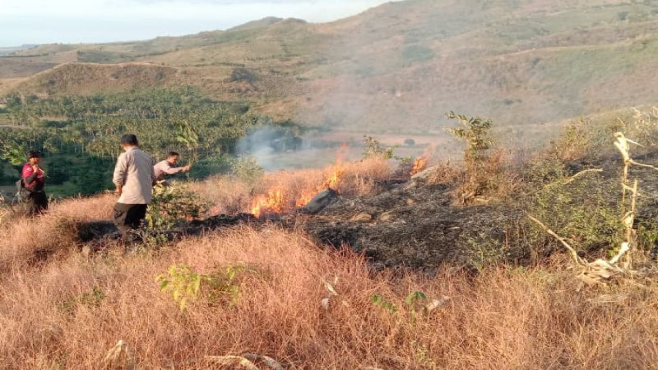 Anggota Polres Dompu melakukan pemadaman kebakaran lahan di daerah setempat (ANTARA/HO-Humas Polres Dompu)