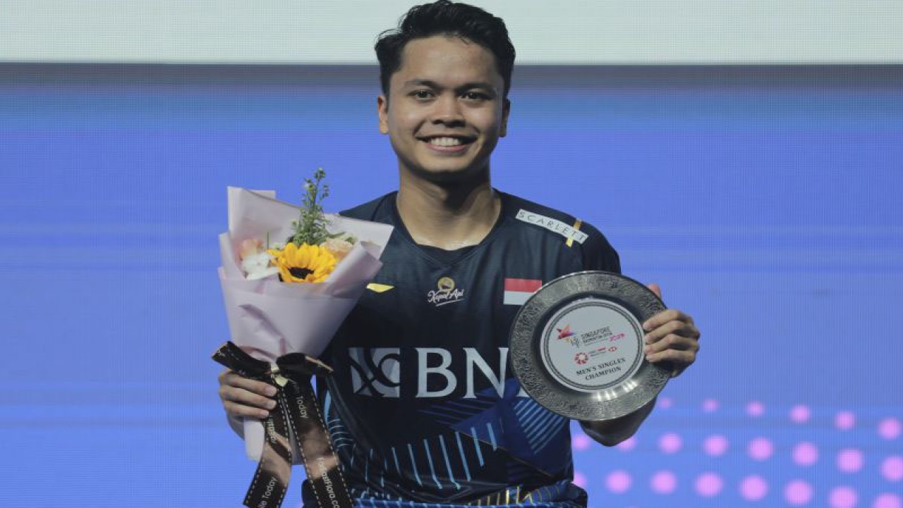 Pebulu tangkis tunggal putra Indonesia Anthony Sinisuka Ginting berfoto dengan pialanya usai mengalahkan pebulu tangkis tunggal putra Denmark Anders Antonsen pada final Singapore Open 2023 di Singapore Indoor Stadium, Minggu (11/6/2023). ANTARA FOTO/Humas PBSI/mrh/nz