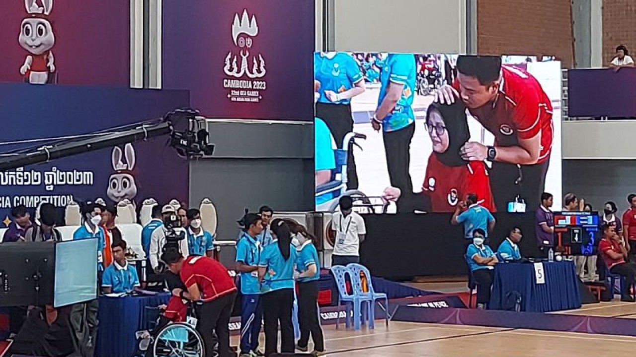 Atlet boccia Indonesia Gischa Zayana ditenangkan oleh pelatihnya usai memenangkan babak semifinal nomor individu putri BC2 melawan tuan rumah Kamboja dengan skor 4-3 di kawasan Komplek Olahraga Olimpiade di Phnom Penh Kamboja, Selasa (6/6/2023). (ANTARA/Aditya Ramadhan)