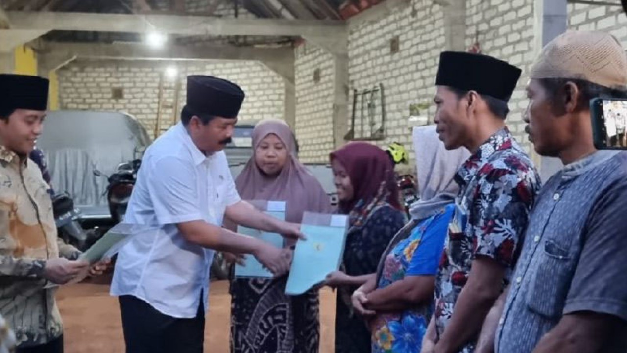 Menteri Agraria Tata Ruang/Badan Pertanahan Nasional (ATR/BPN) Hadi Tjahjanto menyerahkan sertifikat tanah wakaf dan progaram PTSL (pendaftaran tanah sistematis lengkap) di Bangkalan, Jawa Timur, Jumat malam. (ANTARA/HO-Humas BPN Jatim)