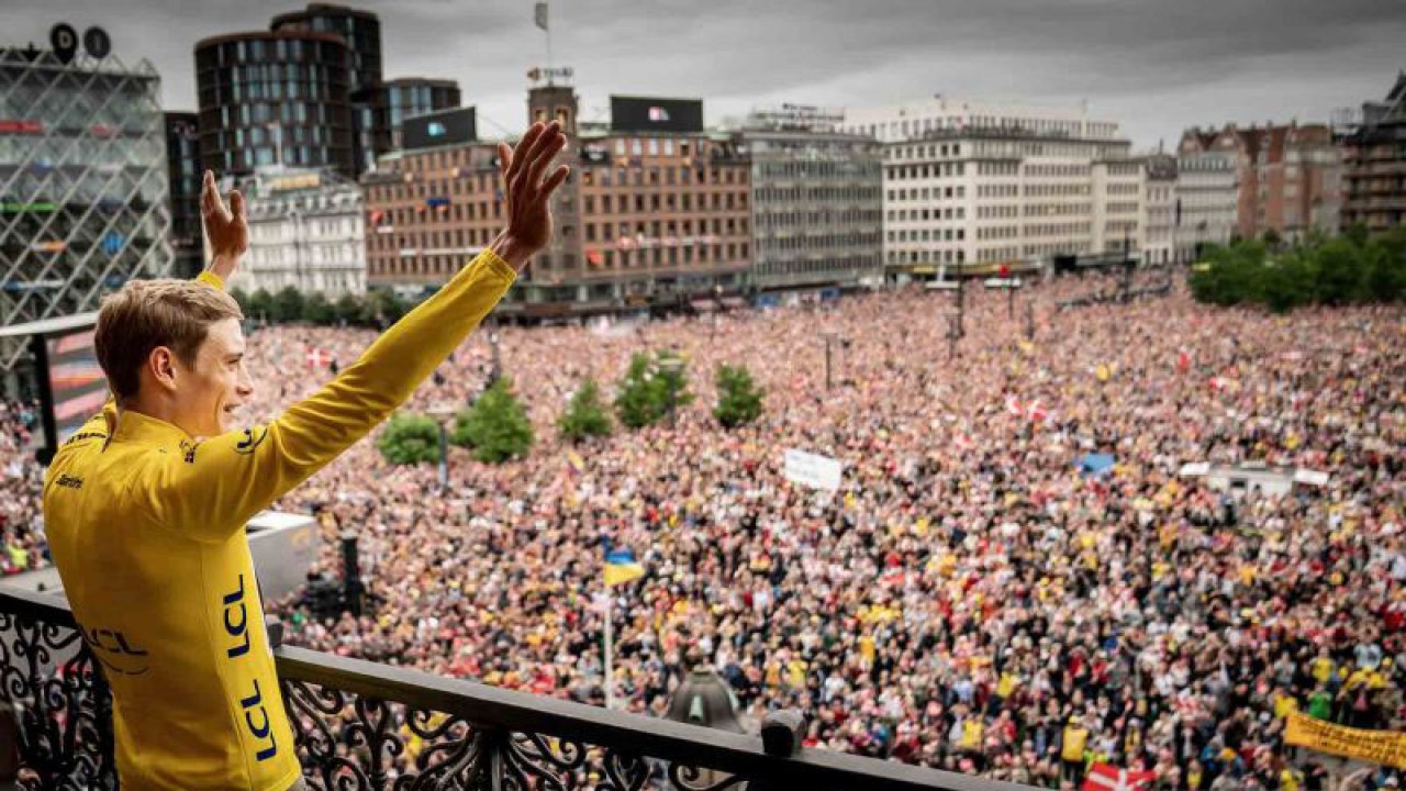 Pembalap sepeda Denmark dari tim Jumbo-Visma Jonas Vingegaard melambaikan tangannya ke arah ribuan warga yang menyambutnya dari atas balkon saat perayaan kemenangan di Kopenhagen, Denmark, Rabu (27/7/2022). Juara Tour de France 2022 Jonas Vingegaard mendarat di Kopenhagen pada Rabu, 27 Juli 2022 dan disambut ribuan warga Denmark yang memadati jalanan tempat ajang balap sepeda terakbar itu dimulai hampir sebulan lalu. ANTARA FOTO/Mads Claus Rasmussen/Ritzau Scanpix via REUTERS/wsj.