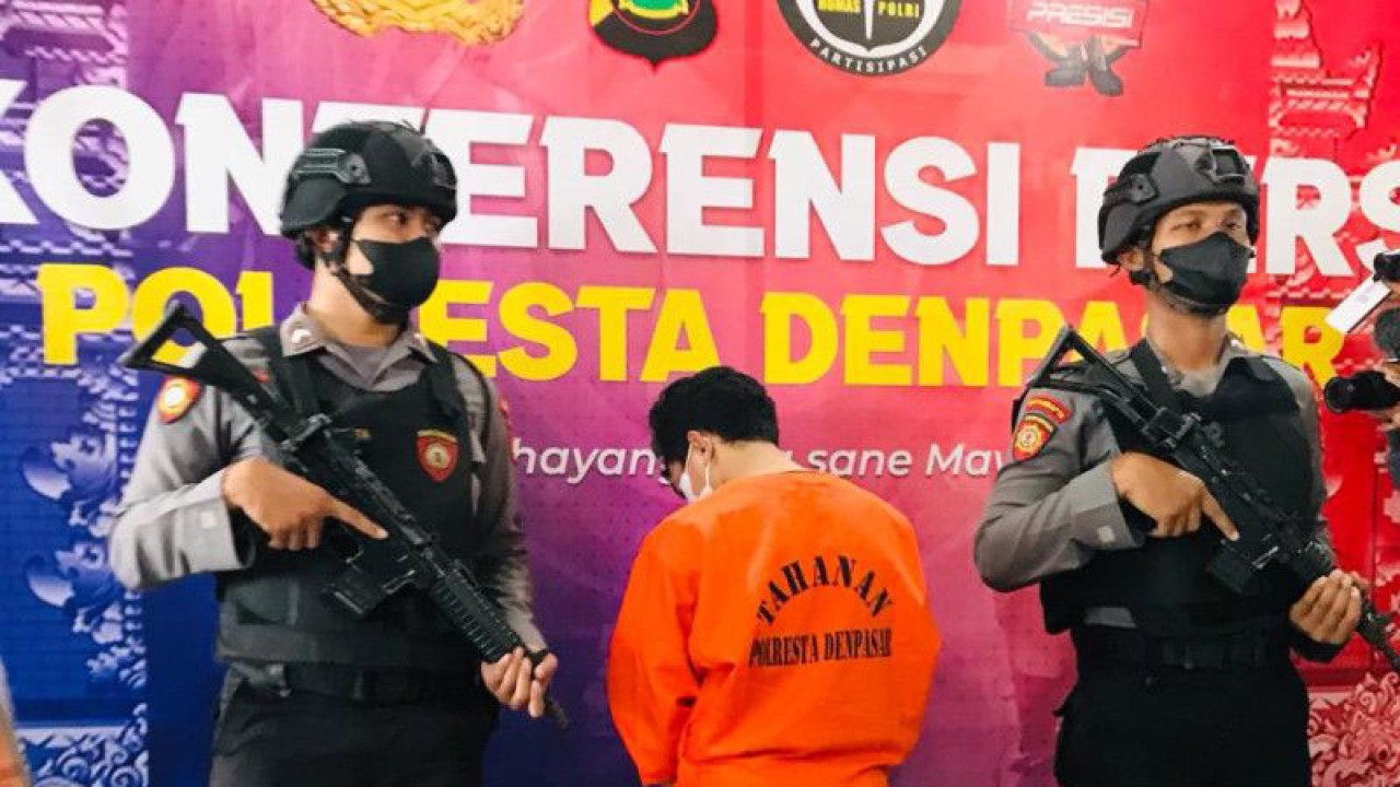 Petugas Kepolisian Resor Kota Denpasar berdiri di samping tersangka ZAM (26) yang melakukan pencabulan terhadap korban anak warga negara Australia di Mako Polresta Denpasar, Bali, Senin (5/6/2023). ANTARA/Rolandus Nampu
