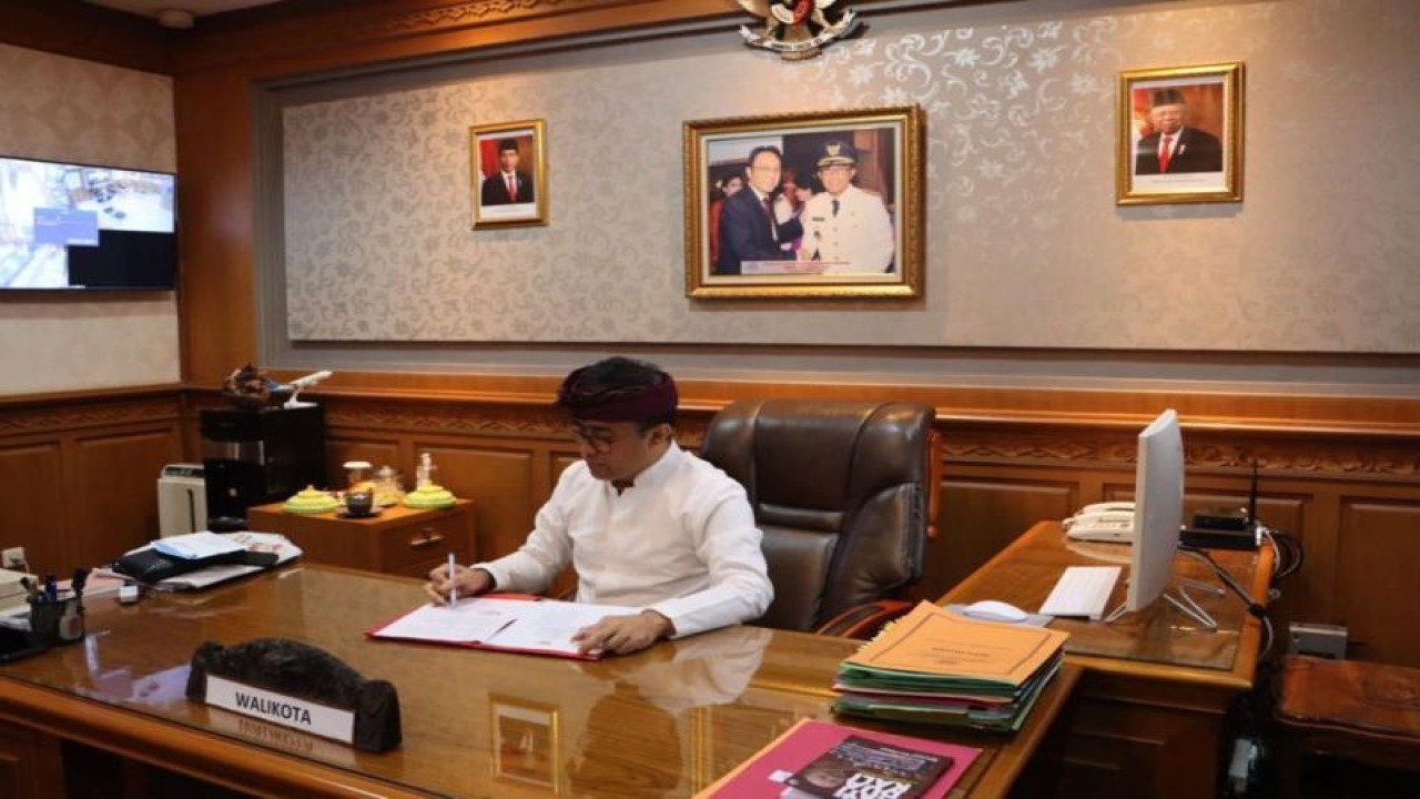 Wali Kota Denpasar, Bali, I Gusti Ngurah Jaya Negara saat menandatangani kesepakatan bersama terkait pengendalian inflasi dari ruang kerjanya di Denpasar, Kamis (15/6/2023). ANTARA/HO-Pemkot Denpasar.