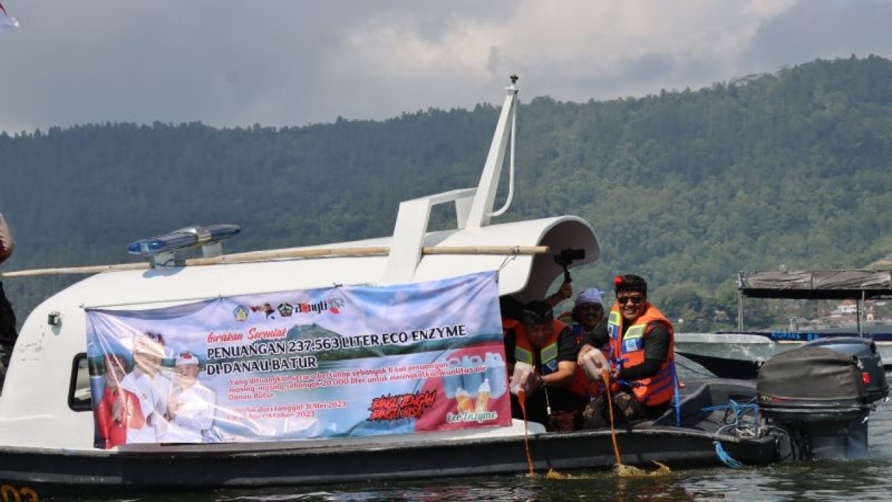 Bupati Bangli Sang Nyoman Sedana Arta sedang menuangkan eco enzime di Danau Batur, Kintamani, guna mengurangi pencemaran. ANTARA/HO-Humas Pemkab Bangli