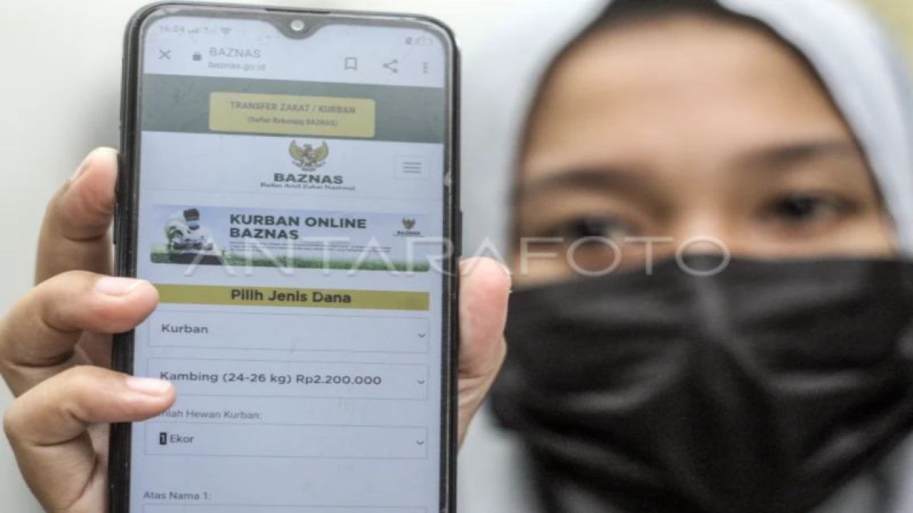 FOTO ARSIP - Warga menunjukan laman resmi Baznas melalui perangkat telepon pintarnya saat akan membeli hewan kurban secara daring di Depok, Jawa Barat, Sabtu (10/7/2021). (ANTARA FOTO/Yulius Satria Wijaya/hp.)