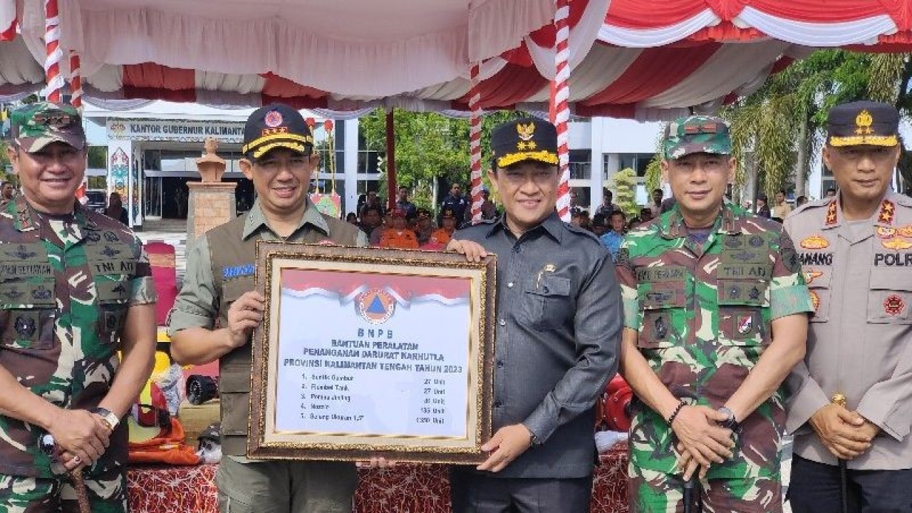 Kepala BNPB Letjen TNI Suharyanto (dua dari kiri) secara simbolis memberikan bantuan peralatan penanganan darurat karhutla kepada Wagub Kalteng Edy Pratowo di Palangka Raya, Jumat, (16/6/2023). (ANTARA/Muhammad Arif Hidayat)