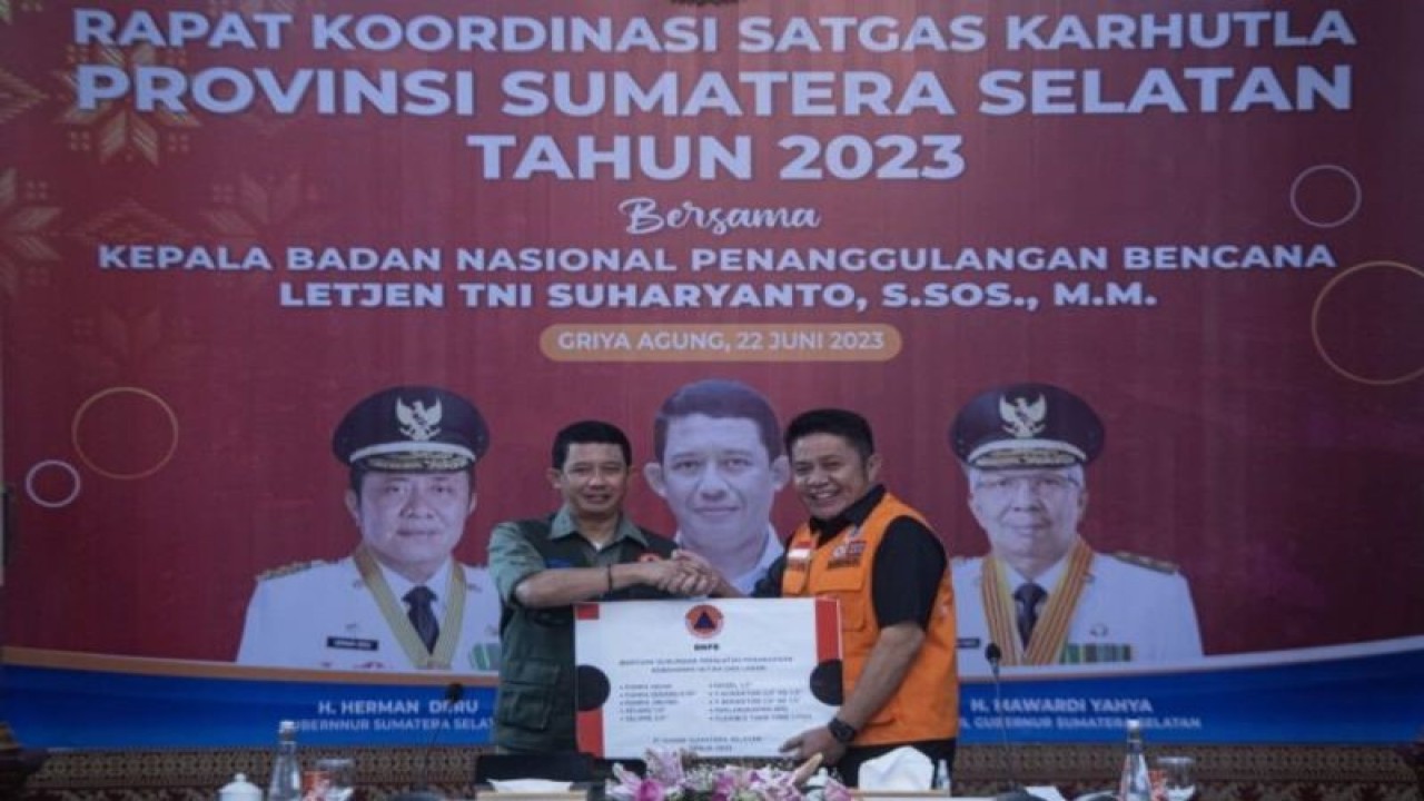 Kepala Badan Nasional Penanggulangan Bencana (BNPB) Letjen TNI Suharyanto (kiri) menyerahkan bantuan peralatan pemadaman kebakaran hutan dan lahan (karhutla) kepada Gubernur Sumatera Selatan Herman Deru (kanan) saat mengikuti Rapat Kordinasi Satgas Karhutla di Palembang, Sumatera Selatan, Kamis (22/6/2023). Rakor tersebut membahas kesiapan pencegahan dan penanganan bencana alam Kebakaran Hutan dan Lahan (Karhutla) selama musim kemarau yang lebih ekstrim akibat pengaruh El Nino di Sumatera Selatan. (ANTARA FOTO/Nova Wahyudi)