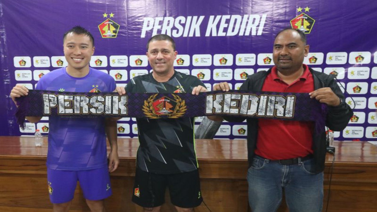 Pelatih baru Persik Kediri Marcelo Rospide (tengah) bersama Direktur Arief Syaiduddin (kanan) dan pesepak bola Arthur Irawan (kiri) membentangkan syal saat rilis pelatih baru Persik Kediri di Kota Kediri, Jawa Timur, Selasa (23/5/2023). ANTARA FOTO/Prasetia Fauzani/tom.