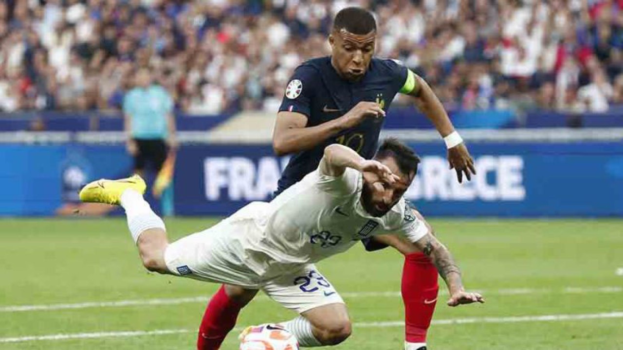 Pemain Prancis Kylian Mbappe berebut bola dengan pemain Yunani Manolis Siopis pada kualifikas Euro 2024 grup B di Stade de France, Saint-Denis, Prancis, Senin (19/6/2023). Gol tunggal Mbappe membawa kemenangan Prancis atas Yunani. ANTARA FOTO/REUTERS/Gonzalo Fuentes/rwa.