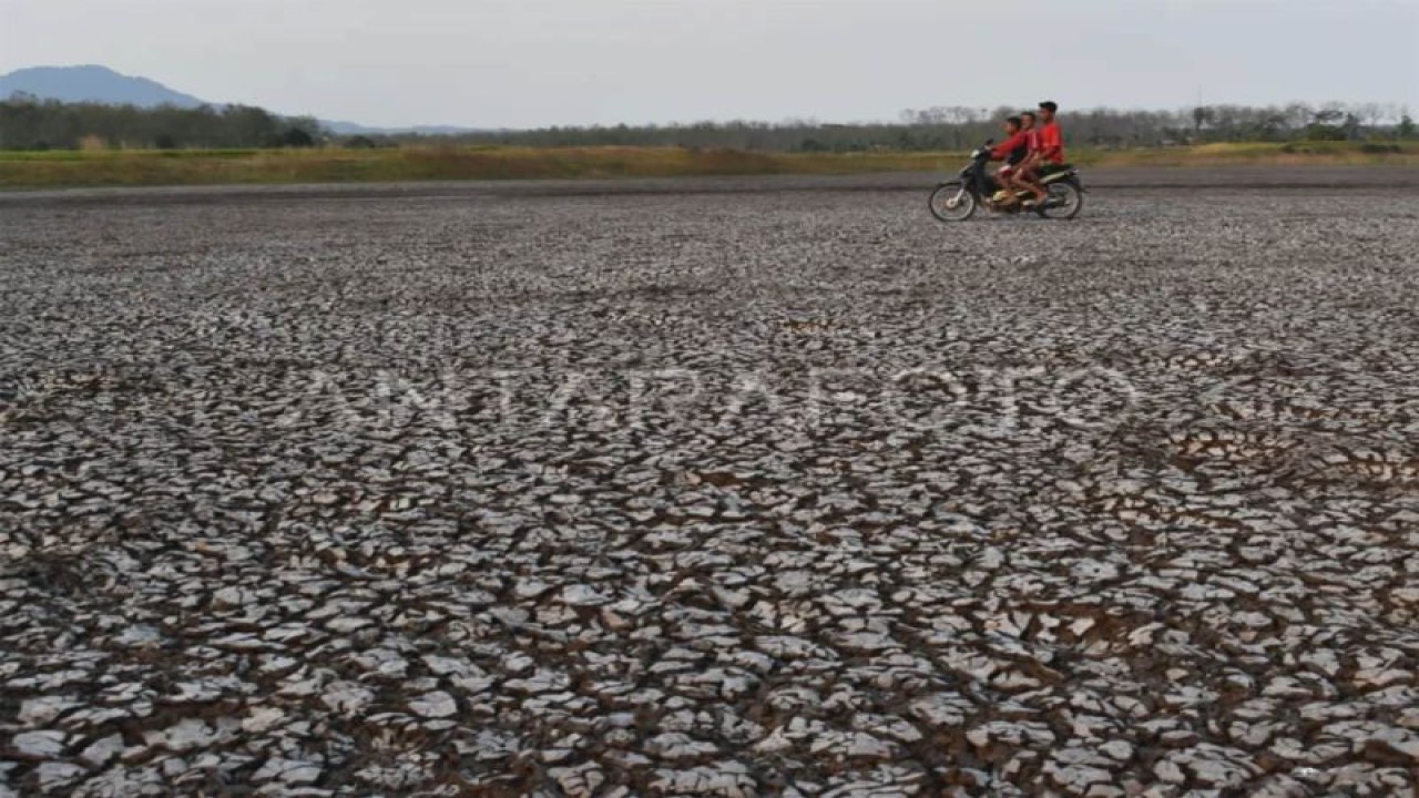 Foto arsip. Tiga orang bocah berboncengan sepeda motor melintas di dasar Waduk Saradan yang mengering di Kabupaten Madiun, Jawa Timur, Rabu (30/10/2019). (ANTARA FOTO/Siswowidodo/ama.)
