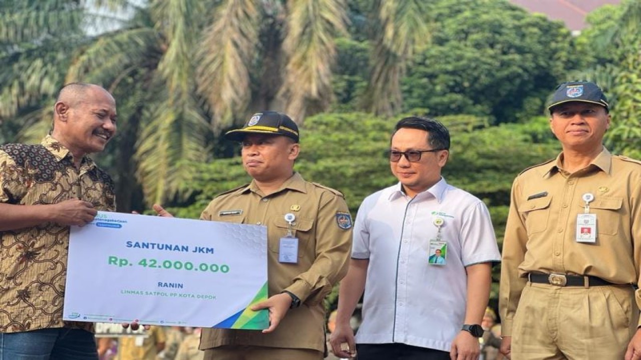 Sekda Depok Supian Suri (kedua dari kiri) dan Kepala Kantor Cabang BPJS Ketenagakerjaan Depok Achiruddin (kedua dari kanan) menyerahkan santunan kematian kepada ahli waris anggota Linmas Satpol PP di Depok, Senin (5/6/2023). (ANTARA/HO)