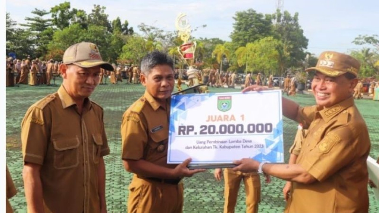 Bupati Tanah Bumbu M. Zairullah Azhar (kanan) menyerahkan hadiah dan uang pembinaan desa. (ANTARA/HO-DPMD Tanah Bumbu)