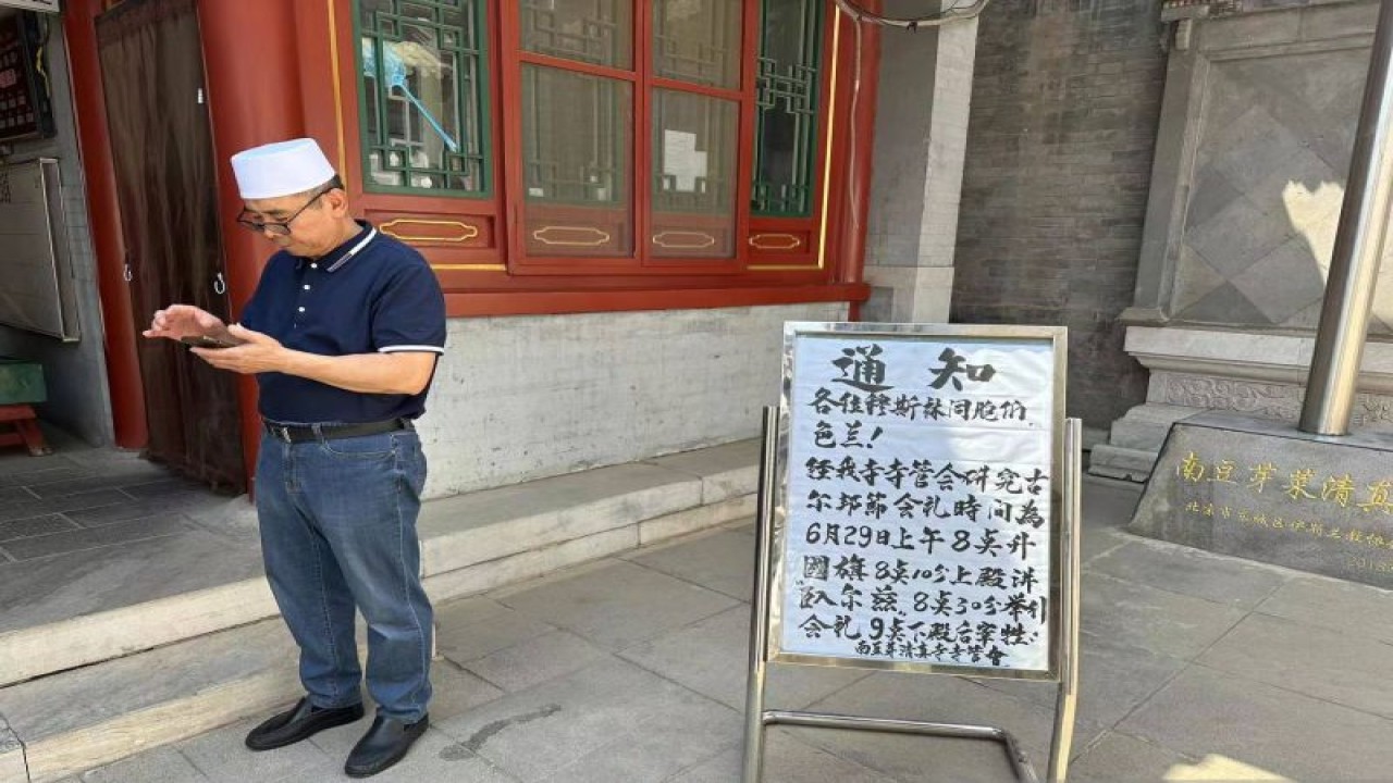 Seorang pengurus Masjid Nanduoya, Beijing, China, Rabu (28/6/2023) berdiri di samping papan pengumuman shalat Idul Adha 10 Dzulhijjah 1444 H yang akan digelar pada Kamis (29/6/2023). (ANTARA/M. Irfan Ilmie)