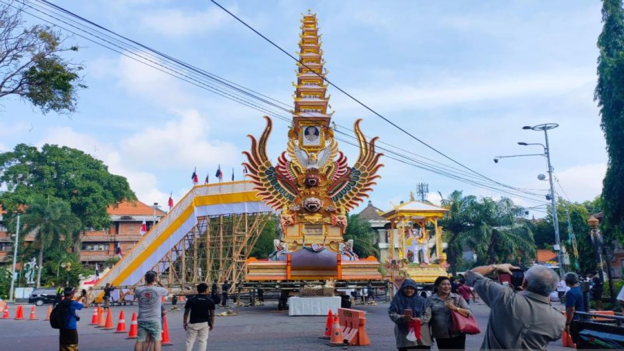 Masyarakat berfoto-foto di depan bade tumpang 11 yang akan digunakan untuk mengarak jenazah Raja Denpasar IX dari Puri Agung Denpasar Ida Tjokorda Ngurah Jambe Pemecutan, di Denpasar, Rabu (21/6/2023). ANTARA/Ni Luh Rhismawati.