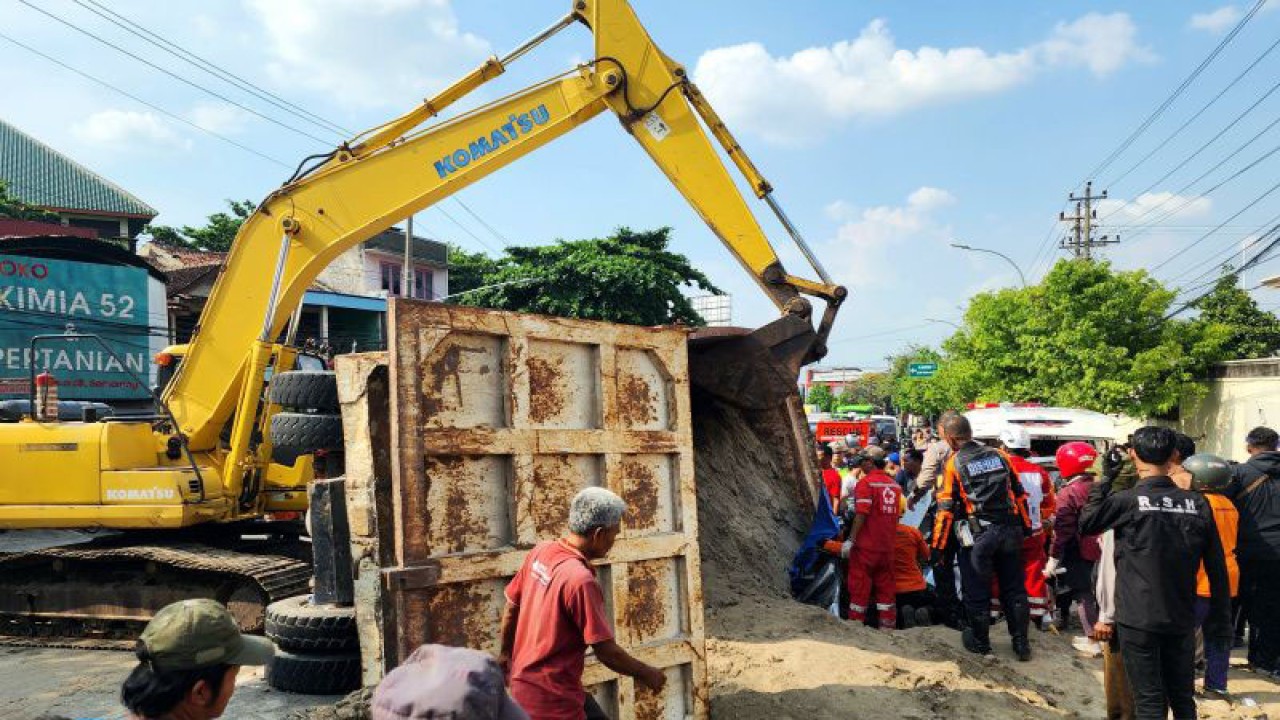 Petugas mengevakuasi korban yang terjebak saat truk pengangkut tanah menimpa sebuah mobil di Semarang, Rabu. ANTARA/ I.C.Senjaya.