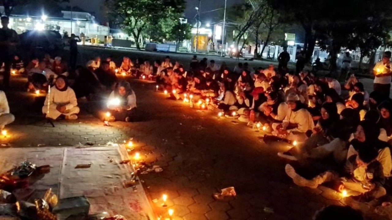 Gerakan perempuan bersatu menggelar doa bersama serta aksi bakar lilin untuk kesembuhan korban asusila berinisial R di halaman parkir Rumah Sakit Umum Daerah (RSUD) Undata, Minggu (4/6/2023). (ANTARA/Nur Amalia Amir)