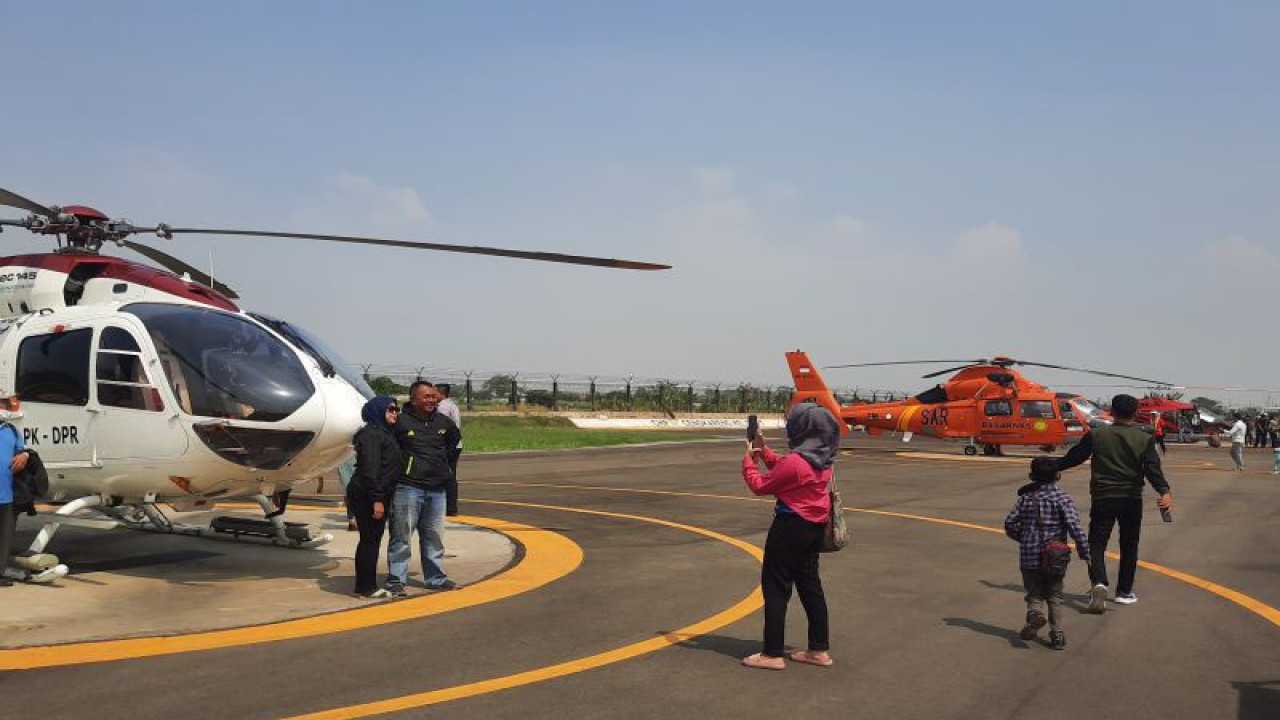 Pengunjung saat berfoto di sejumlah jajaran Helikopter yang dipamerkan dalam kegiatan Heli Expo Asia 2023 di Cengkareng Heliport, Tangerang, Banten pada Kamis. (Azmi Samsul Maarif)