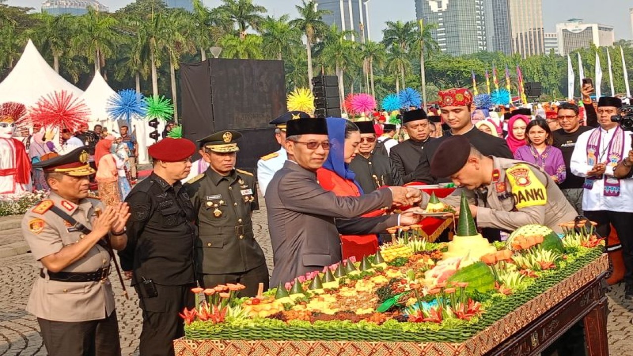 Penjabat (Pj) Gubernur DKI Jakarta Heru Budi Hartono melaksanakan pemotongan tumpeng sebagai bentuk Tasyakuran HUT ke-496 Kota Jakata bersama Pasukan Pelangi, TNI/Polri, Pasukan berseragam PDL di lapangan upacara, Kamis (22/6/2023). ANTARA/Siti Nurhaliza