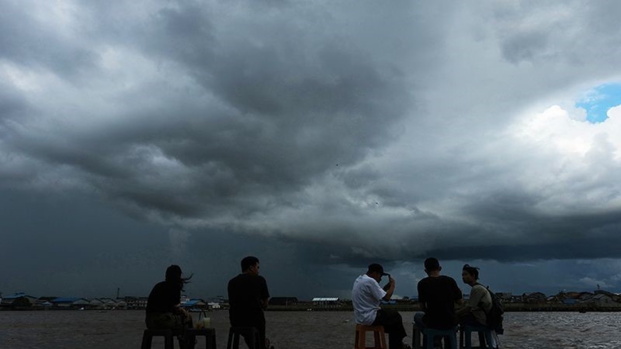Arsip Foto - Warga duduk di tepi Sungai Kapuas saat mendung penanda hujan meliputi bagian langit di atas Kota Pontianak, Provinsi Kalimantan Barat, Sabtu (25/3/2023). ANTARA FOTO/Jessica Helena Wuysang/tom/pri.