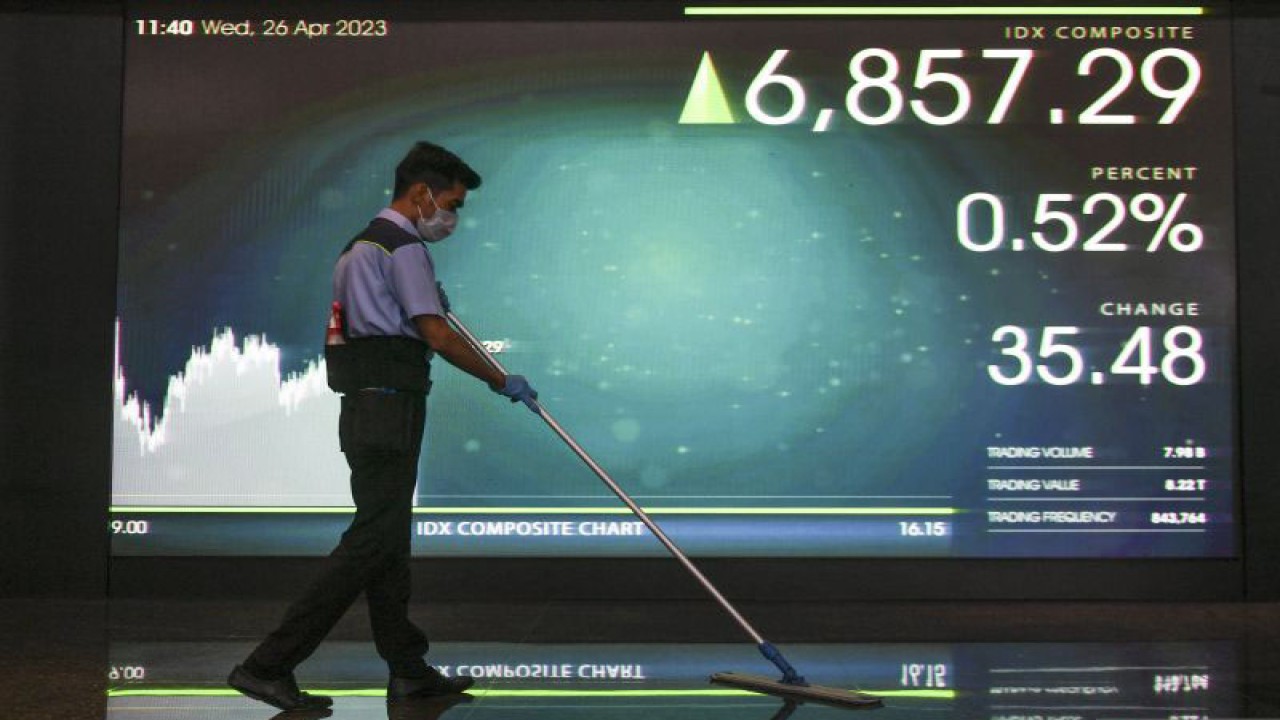 Pekerja membersihkan lantai di depan layar yang menampilkan pergerakan Indeks Harga Saham Gabungan (IHSG) di Bursa Efek Indonesia, Jakarta, Rabu (26/4/2023). ANTARA FOTO/Hafidz Mubarak A/foc.