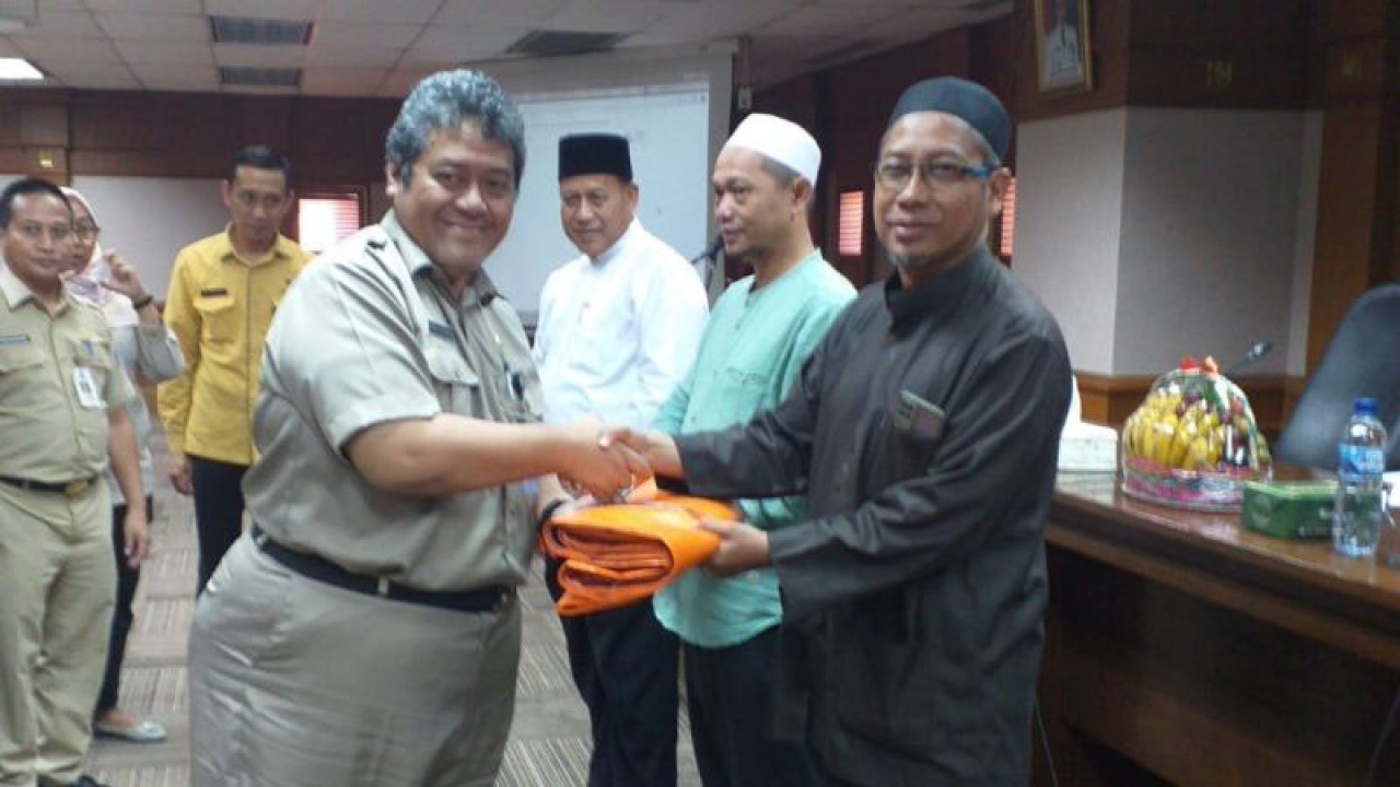Sekretaris Kota Jakarta Barat, Indra Patrianto memberikan simbolis terpal sebagai alas pemotongan hewan kurban kepada perwakilan panitia pemotongan hewan kurban Jakarta Barat, Selasa (20/6/2023). ANTARA/Risky Syukur
