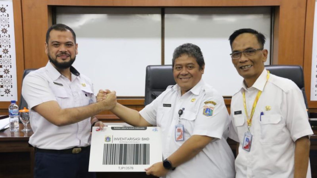 Sekretaris Kota Jakarta Barat, Indra Patrianto (tengah) bersama Kepala Suku Badan Pengelolaan Aset Daerah Pemkot Jakarta Barat, Sigit Gunawan (kanan) dalam serah terima kode batang (barcode) hasil inventarisasi gedung dan bangunan aset DKI Jakarta, Rabu (21/6/2023). ANTARA/Risky Syukur