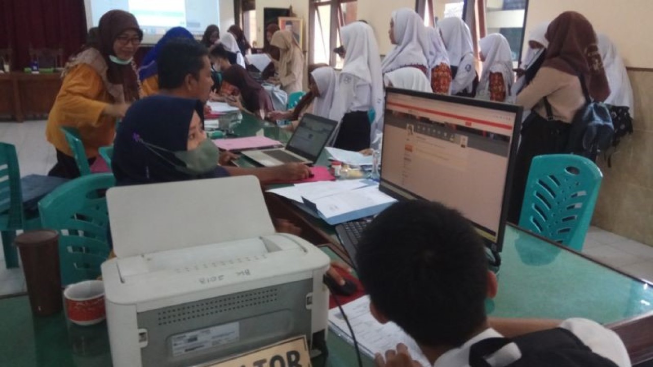 Seorang guru membantu calon peserta didik membuat akun untuk mengikuti Penerimaan Peserta Didik Baru (PPDB) tahun 2023 di SMA 2 Kudus, Jawa Tengah. (ANTARA/Akhmad Nazaruddin Lathif)