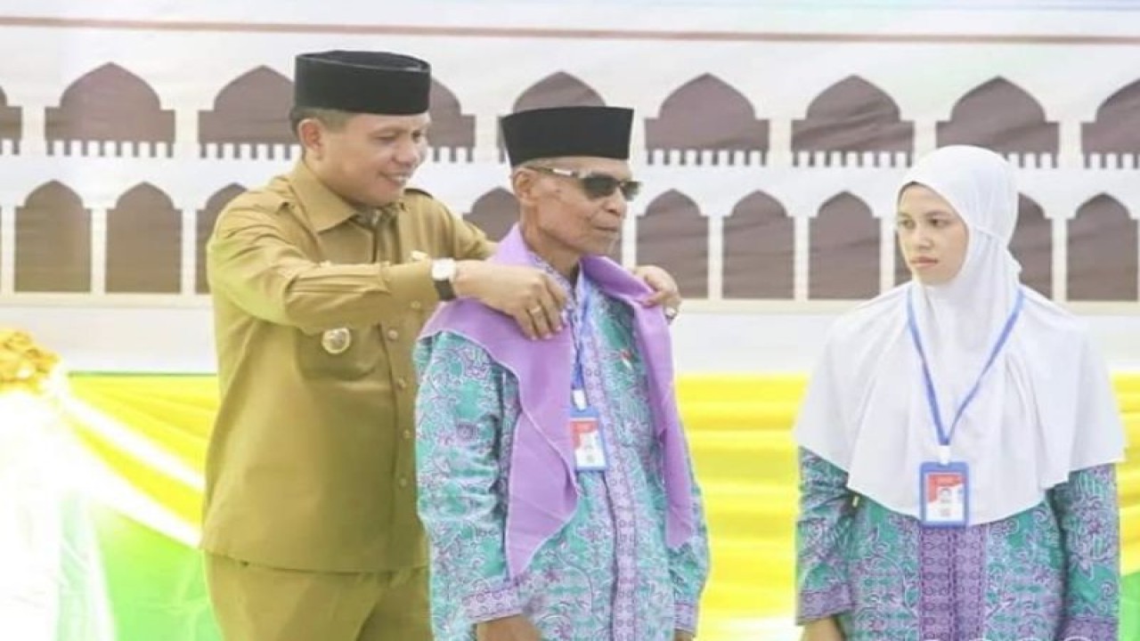 Penjabat Wali Kota Ambon Bodewin Wattimena memasangkan syal kepada seorang calon haji berusia 93 tahun lima bulan atas nama Ja'far Naya Binti Ahmad Naya, saat pelepasan JCH Kota Ambon, Senin (12/6/2023). ANTARA/Penina F. Mayaut