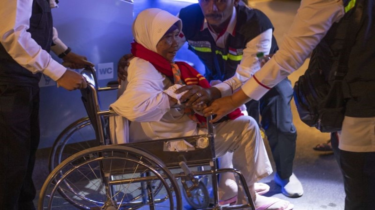 Petugas membantu jemaah calon haji kloter SOC 01 dengan menggunakan kursi roda setibanya di Hotel kawasan Mekah, Arab Saudi, Kamis (1/6/2023). (ANTARA FOTO/WAHYU PUTRO A)
