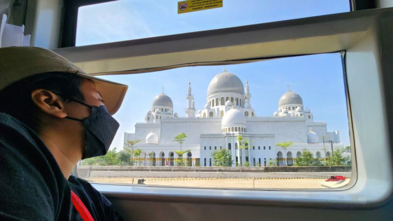 Seorang penumpang KA Banyubiru tujuan Semarang-Solo menikmati pemandangan Masjid Raya Sheikh Zayed di Solo, Kamis. (ANTARA/ I.C.Senjaya)