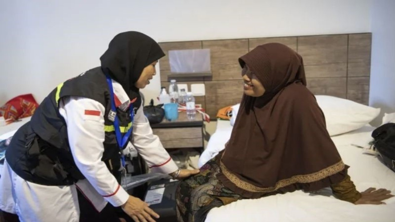 Konsultan ibadah PPIH Arab Saudi, Umi Musyarrofah (kiri) memberikan bimbingan kepada Sumiah (62), Istri almarhum Suprapto yang merupakan jamaah pertama yang meninggal di kamar hotel kawasan Mekkah, Arab Saudi, Senin (5/6). (ANTARA FOTO/WAHYU PUTRO).