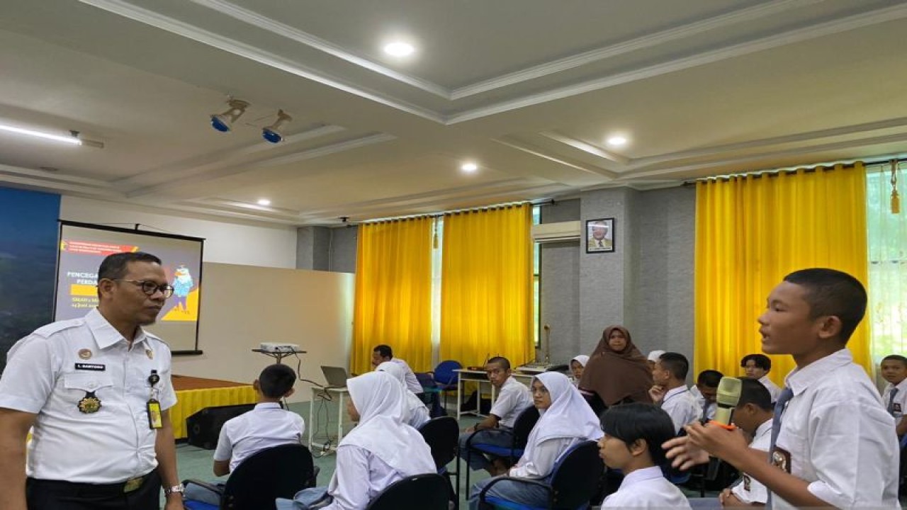 Kepala Bidang Perizinan dan Informasi Keimigrasian Kemenkumham Sumut Imam Santoso (kiri) saat kegiatan sosialisasi TPPO di SMAN 1 Plus Matauli, Pandan, Kabupaten Tapanuli Tengah. (ANTARA/HO-Humas Kemenkumham Sumut)