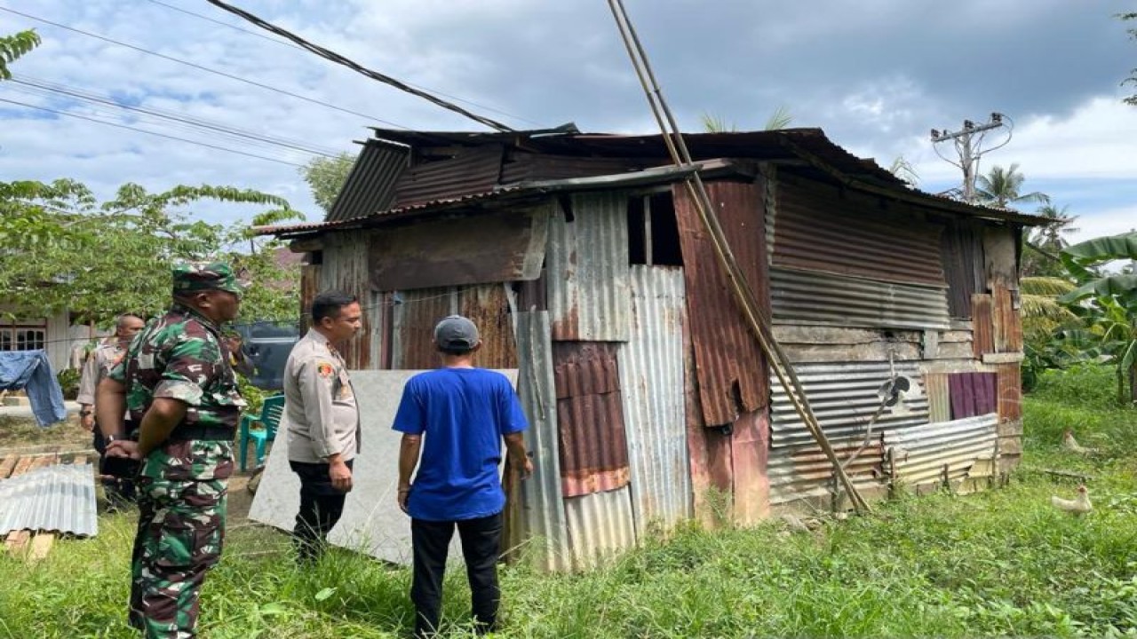 Aparat kepolisian Polres Kolaka saat akan membedah salah satu rumah warga kurang mampu di wilayah itu. (Antara/Darwis)