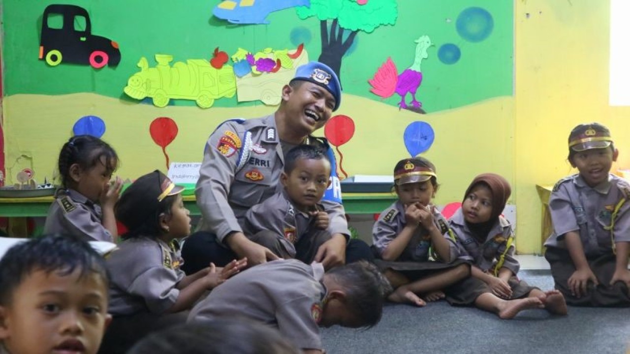 Anggota Subbid Provos Bidpropam Polda Daerah Istimewa Yogyakarta (DIY), sekaligus pendiri TK Bumi Damai Indonesia, Bripka Heri Prasetyo bermain bersama murid TK tersebut di Dusun Krambil, Desa Girisekar, Kec. Panggang, Kab. Gunungkidul, DIY, Selasa (20/6/2023). (ANTARA/Fath Putra Mulya)