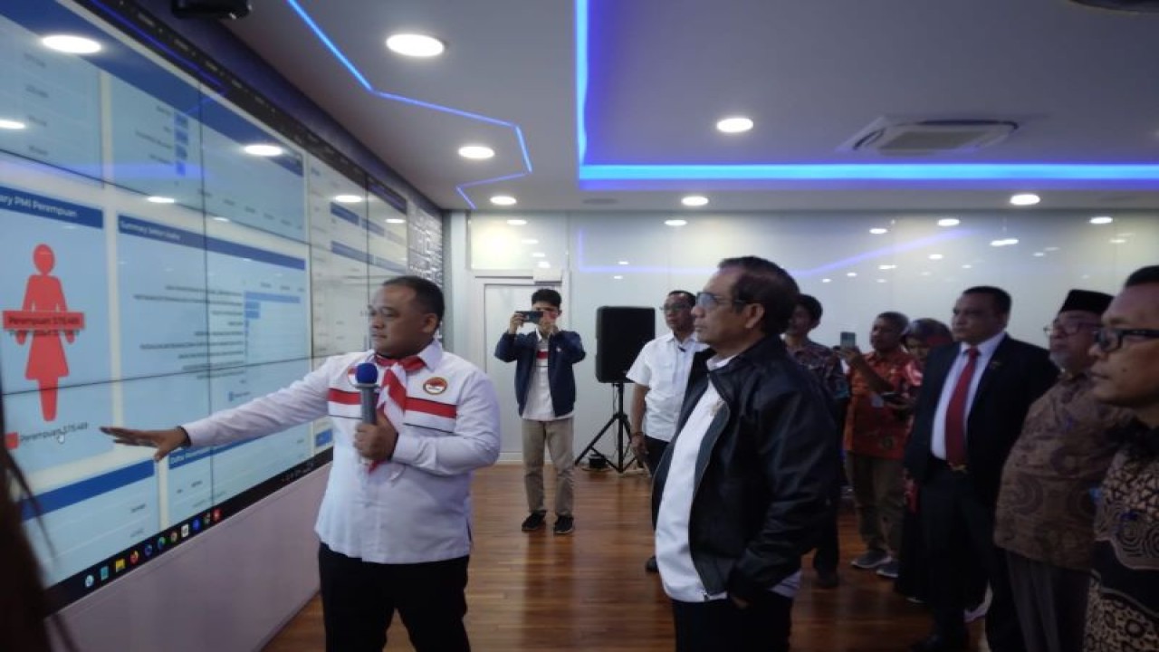 Menteri Koordinator Bidang Politik, Hukum dan Keamanan (Menko Polhukam), Mahfud MD (tengah) menyimak penjelasan Kepala Badan Pelindungan Pekerja Migran Indonesia (BP2MI) Benny Ramdhani (kiri) tentang teknologi informasi di kantor BP2MI, Jakarta, Senin (19/6/2023). (ANTARA/HO-BP2MI)