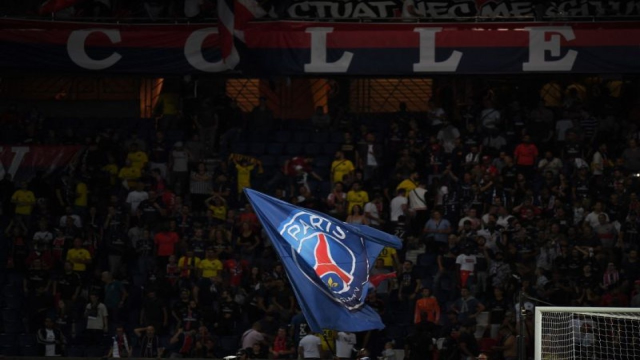 Ilustrasi - Pendukung mengibarkan bendera dengan logo klub Paris Saint-Germain saat pertandingan Liga Prancis antara PSG melawan Caen di Parc des Princes, Paris. (12/8/2018) (AFP/CHRISTOPHE ARCHAMBAULT)