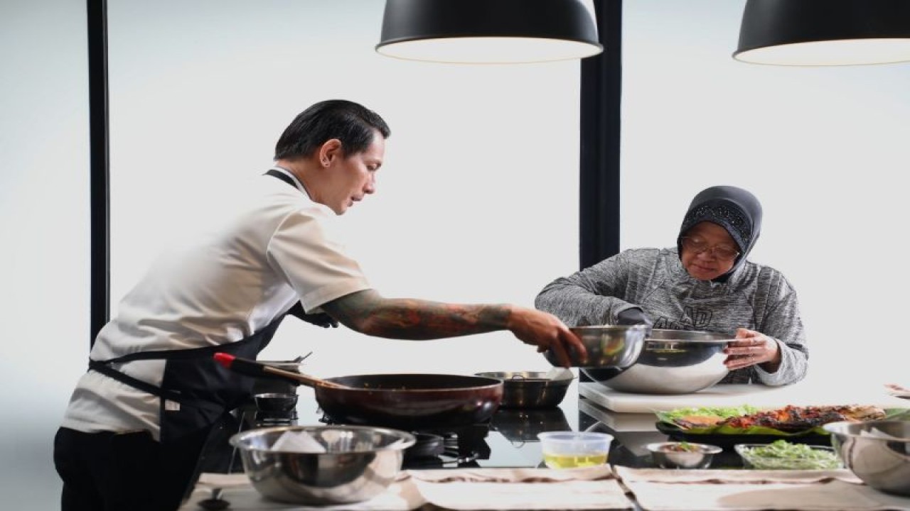 Momen ketika Menteri Sosial RI Tri Rismaharini membantu Chef Juna Rorimpandey mengaduk hidangan urap. (ANTARA/HO-Kemensos)