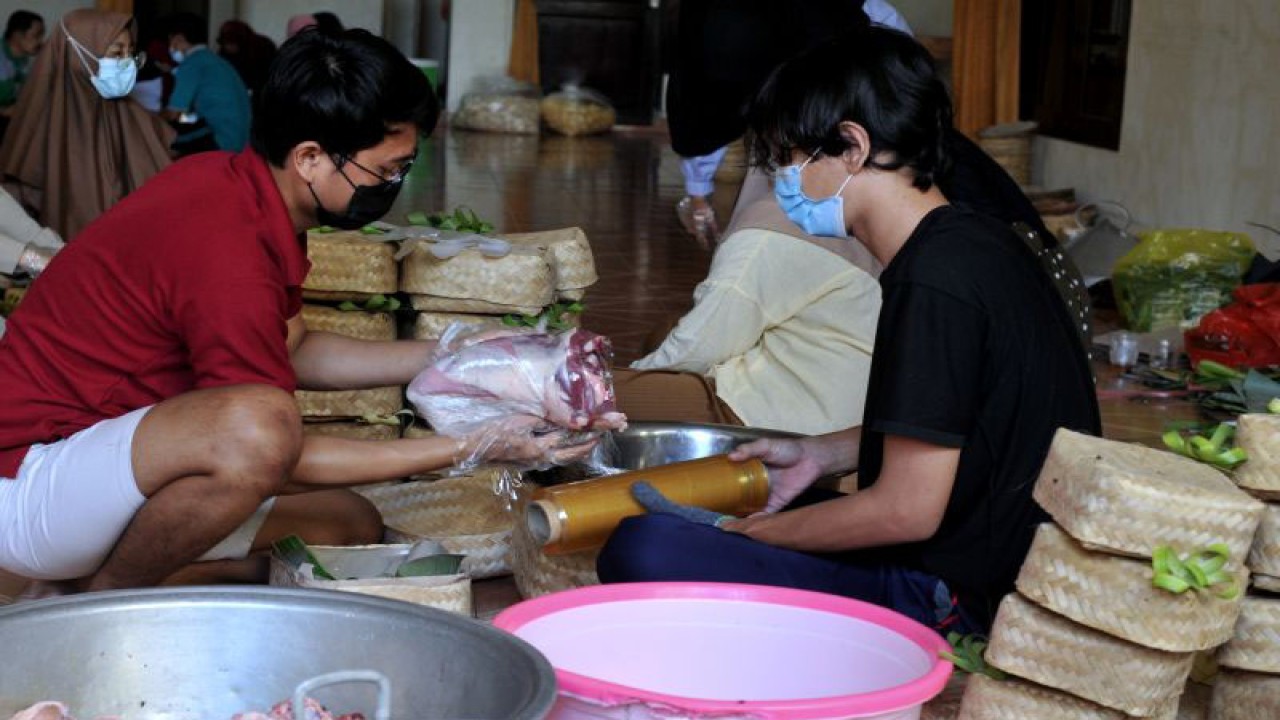 Arsip Foto - Panitia kurban mengemas daging hewan kurban yang akan dibagikan kepada warga di Padangsambian, Denpasar, Bali, Selasa (20/7/2021). (ANTARA FOTO/FIKRI YUSUF)