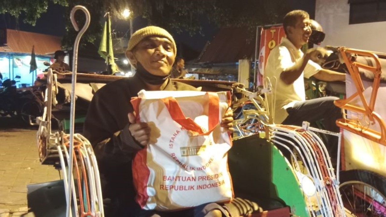 Wawan Siswantoro (56), pengemudi becak di kawasan Alun-alun Utara, Kota Yogyakarta menerima paket sembako dari Presiden Joko Widodo pada Kamis malam (1/6). ANTARA/Luqman Hakim.