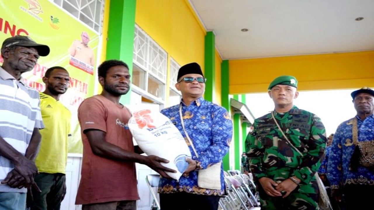 Penjabat Bupati Mappi Michael Gomar (ketiga dari kanan) saat menyerahkan bantuan beras bagi warga (ANTARA/HO-Humas Pemkab Mappi)
