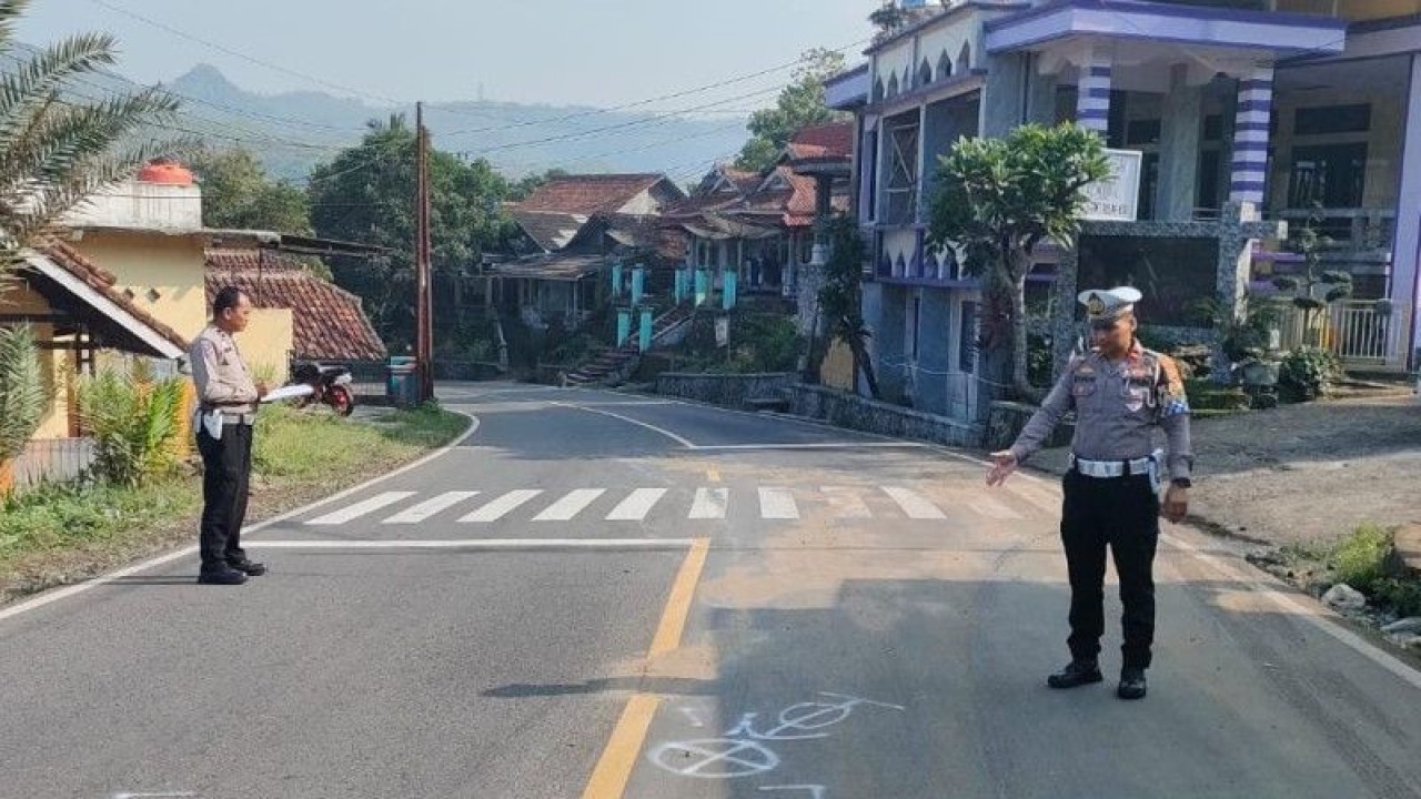 Personel Satlantas Polres Sukabumi menunjukkan lokasi kecelakaan yang menewaskan seorang pengendara motor setelah ditabrak oleh sebuah mobil di Jalan Raya Palabuhanratu, Kampung Sindangsari, Desa/Kecamatan Bantargadung, Kabupaten Sukabumi, Jawa Barat, pada Selasa (13/6/2023). (ANTARA/Aditya Rohman)